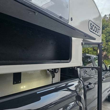 Scout truck camper with open storage on a pickup, ideal for RV rental adventures. Ready for travel.