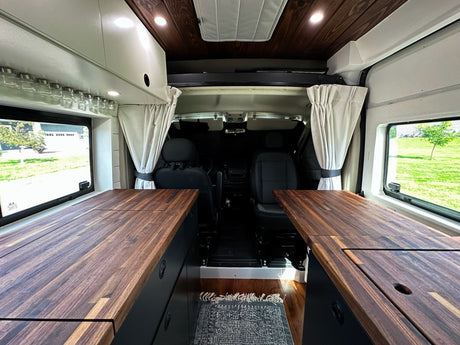 Explore this stunning camper van RV rental interior! Custom wood counters & ceiling, smart storage, and cozy lighting.
