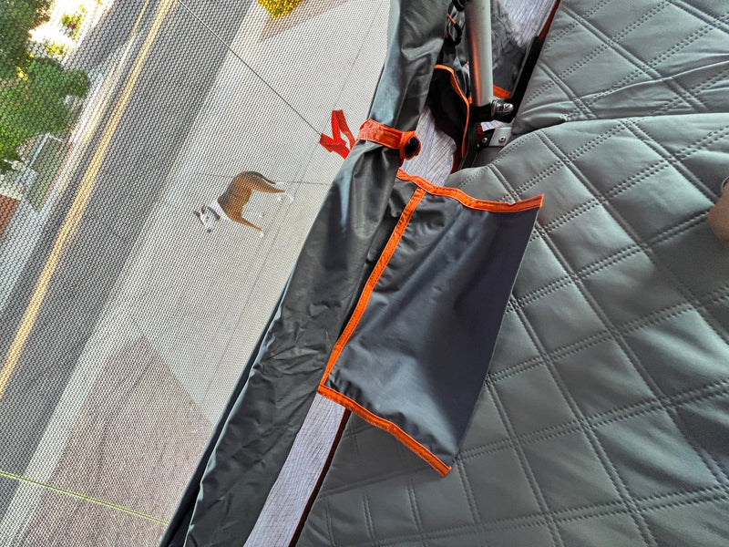 RV rental: Inside, looking out through the screen at a dog on the road, with quilted grey interior. — photo 10