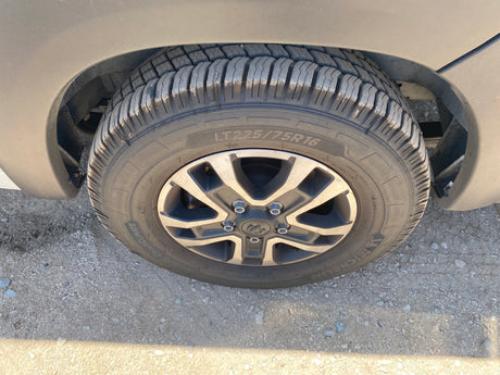 RV rental vehicle's Michelin LT225/75R16 tire & Ram wheel on gravel, showing deep tread.