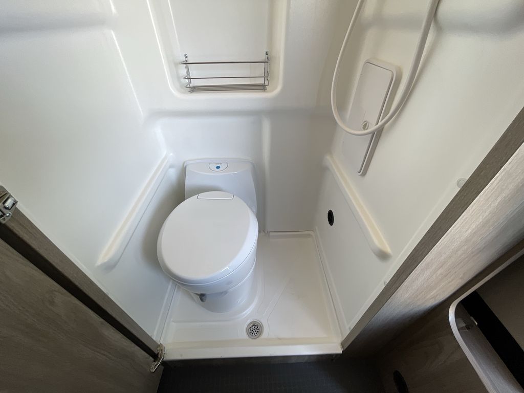  and ample storage. Ready for adventure!|Cozy RV rental interior: an inflatable mattress forms a bed over the front seats for easy van life camping.|Cozy RV rental bedroom with striped bedding and sleeping bag — photo 12