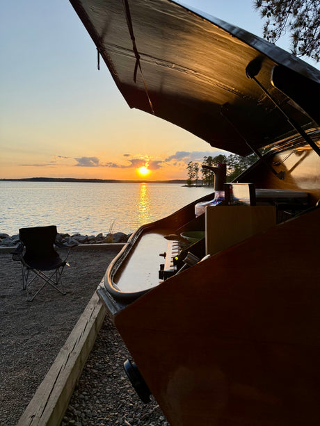 An rv rental's open kitchen provides a cozy cooking spot with stunning lake sunset views. Ideal for lakeside camping.