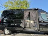 Black camper van for rv rental with open side door. Interior kitchen setup: sink, cabinets, & mosquito net visible.
