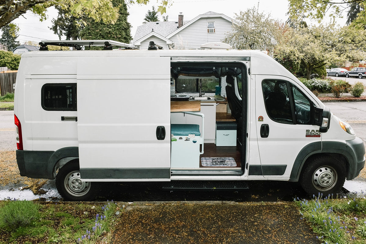 This white RV rental camper van shows its open side door