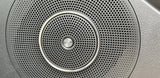 RV rental: High-fidelity B&O audio speaker grille, showing perforated pattern and chrome ring.