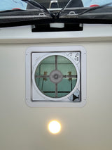 RV rental overhead view: MaxxAir ceiling vent fan with screen, an overhead light, and a black mesh privacy screen.