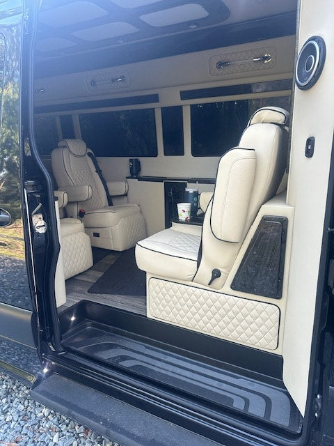  and wall-mounted TV.|Luxury RV rental interior featuring a stylish wet bar with various glassware — photo 2