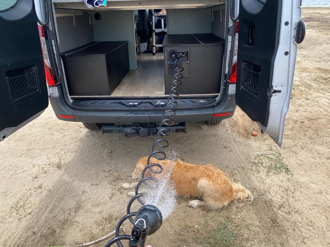  perfect for an rv rental adventure.|Mobile dog wash after a beach day! This RV rental has a built-in outdoor shower for pets on the go.|An `rv rental` Sprinter van with a child and dog — photo 3