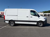 Side view of a white cargo van, a common choice for RV rental conversions, parked in a sunny lot.