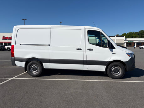 Side view of a white cargo van, a common choice for RV rental conversions, parked in a sunny lot.