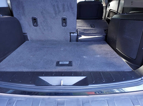 View of a vehicle's spacious rear cargo area, with seats folded flat for maximum storage. Ideal for packing gear for an rv rental.