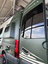 Matte green Entegra Launch RV, perfect for rv rental adventures, featuring open rear door and power hookup.