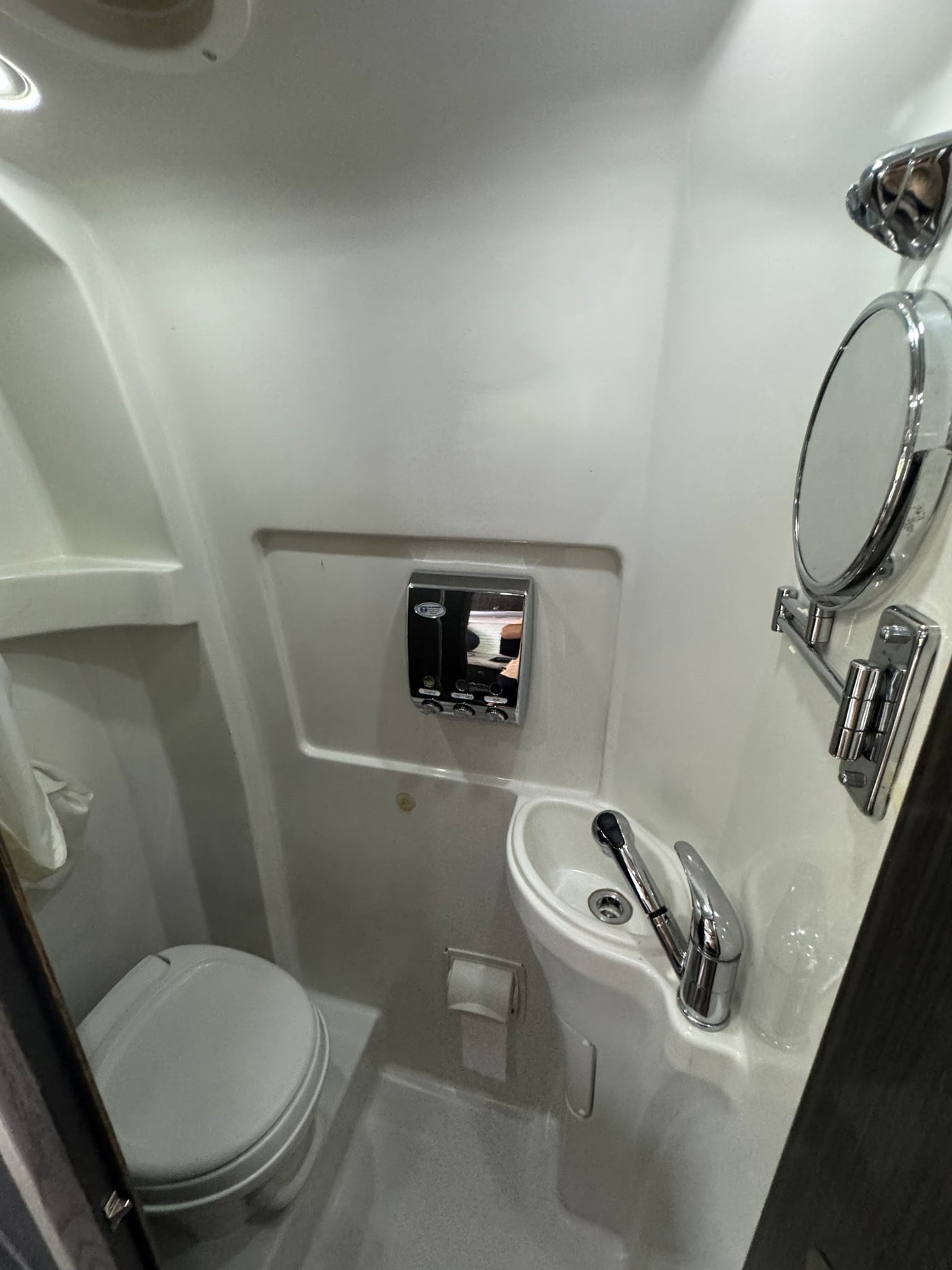 Compact RV rental wet bath featuring toilet, sink, and shower. Ideal for space-saving travel. — photo 6