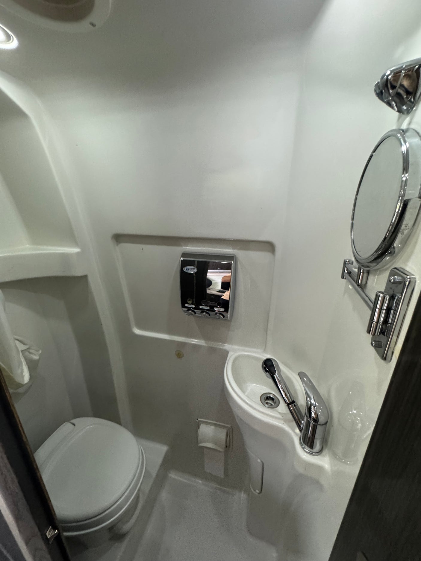 Compact RV rental wet bath featuring toilet, sink, and shower. Ideal for space-saving travel.