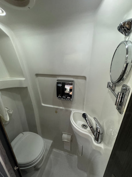 Compact RV rental wet bath featuring toilet, sink, and shower. Ideal for space-saving travel.