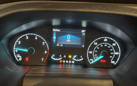 This RV rental's dashboard displays 0 mph, 59° ambient temperature, low fuel, and illuminated brake/door warning indicators.