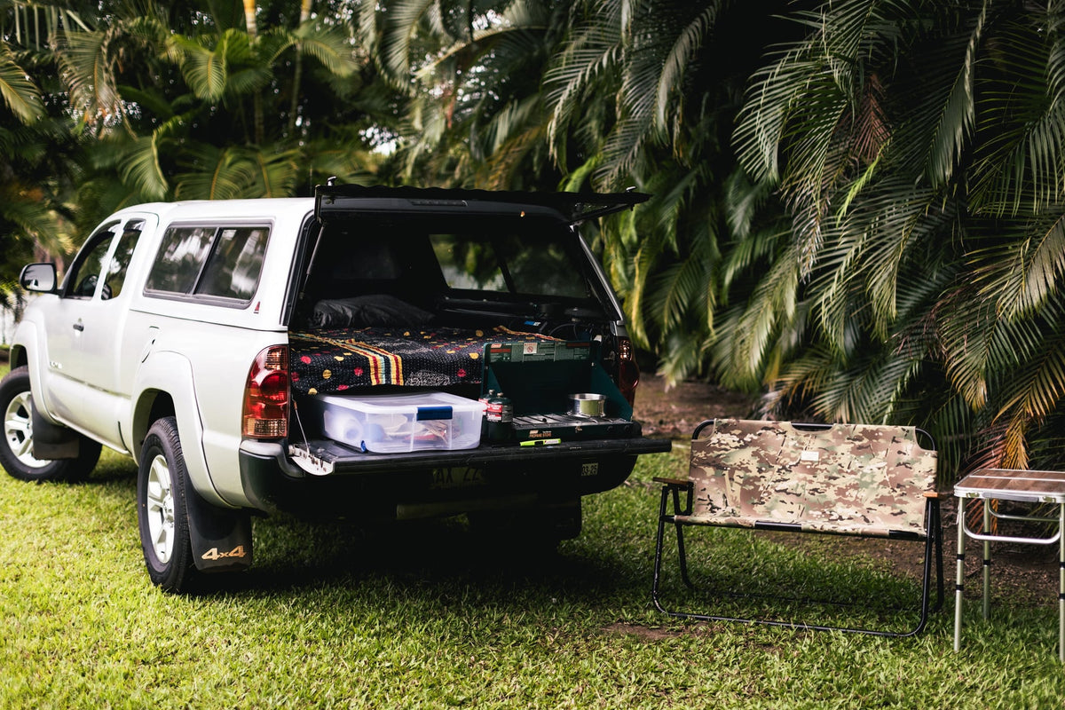  with string lights illuminating the cabin and a blurred view of nature outside the window.|Silver pickup truck RV rental — photo 11