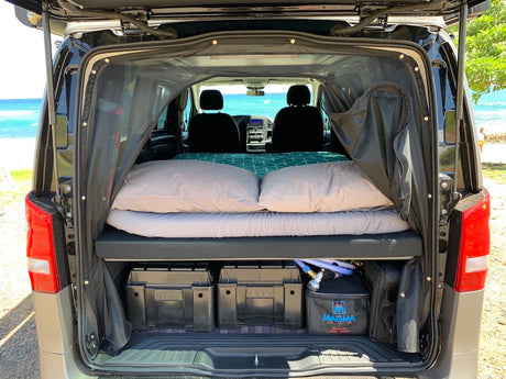 This RV rental campervan features a cozy bed, ample storage, and ocean views for your next camping road trip.