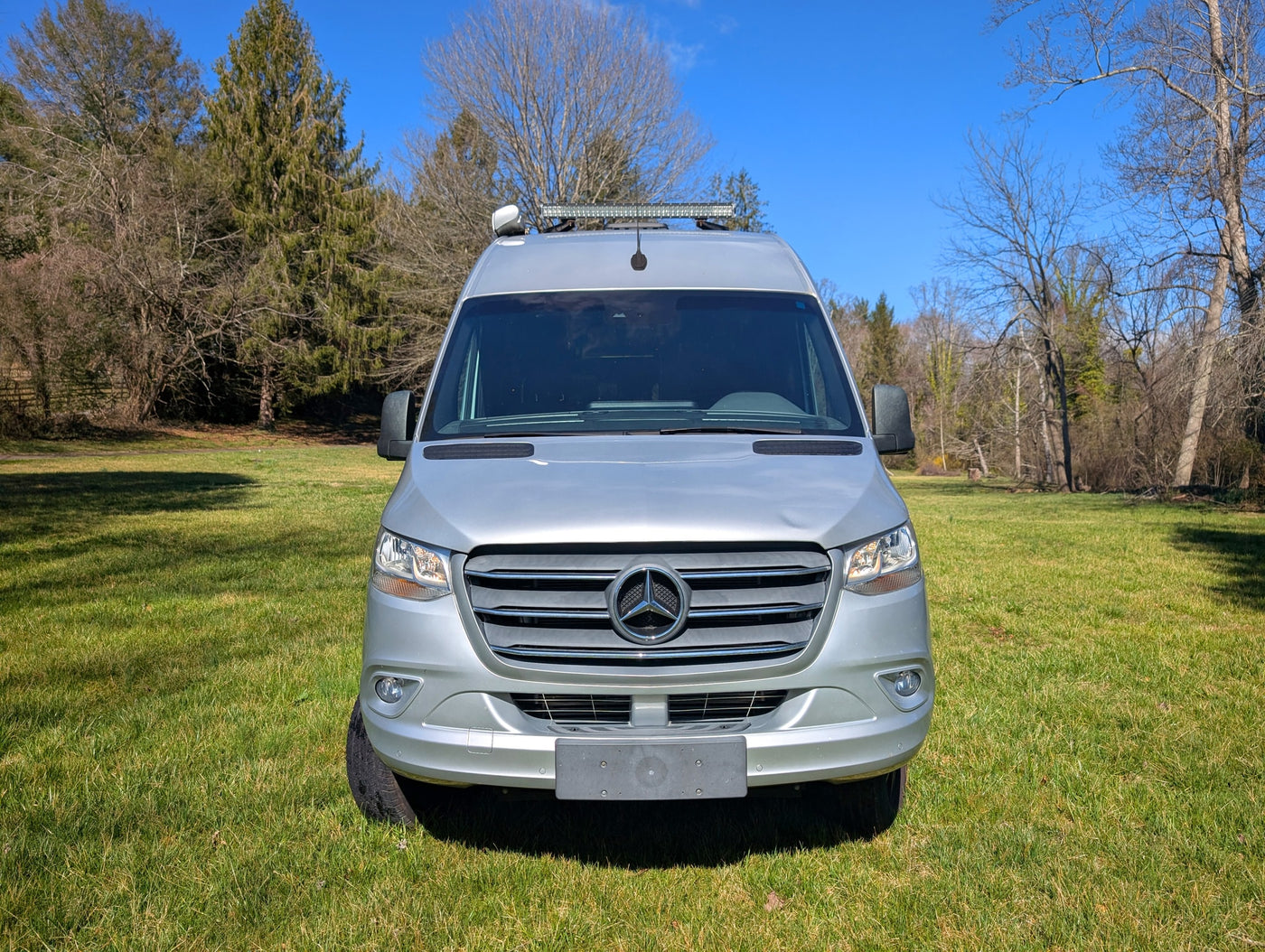  parked on green grass.|Spacious RV rental's front cabin interior with dashboard — photo 5