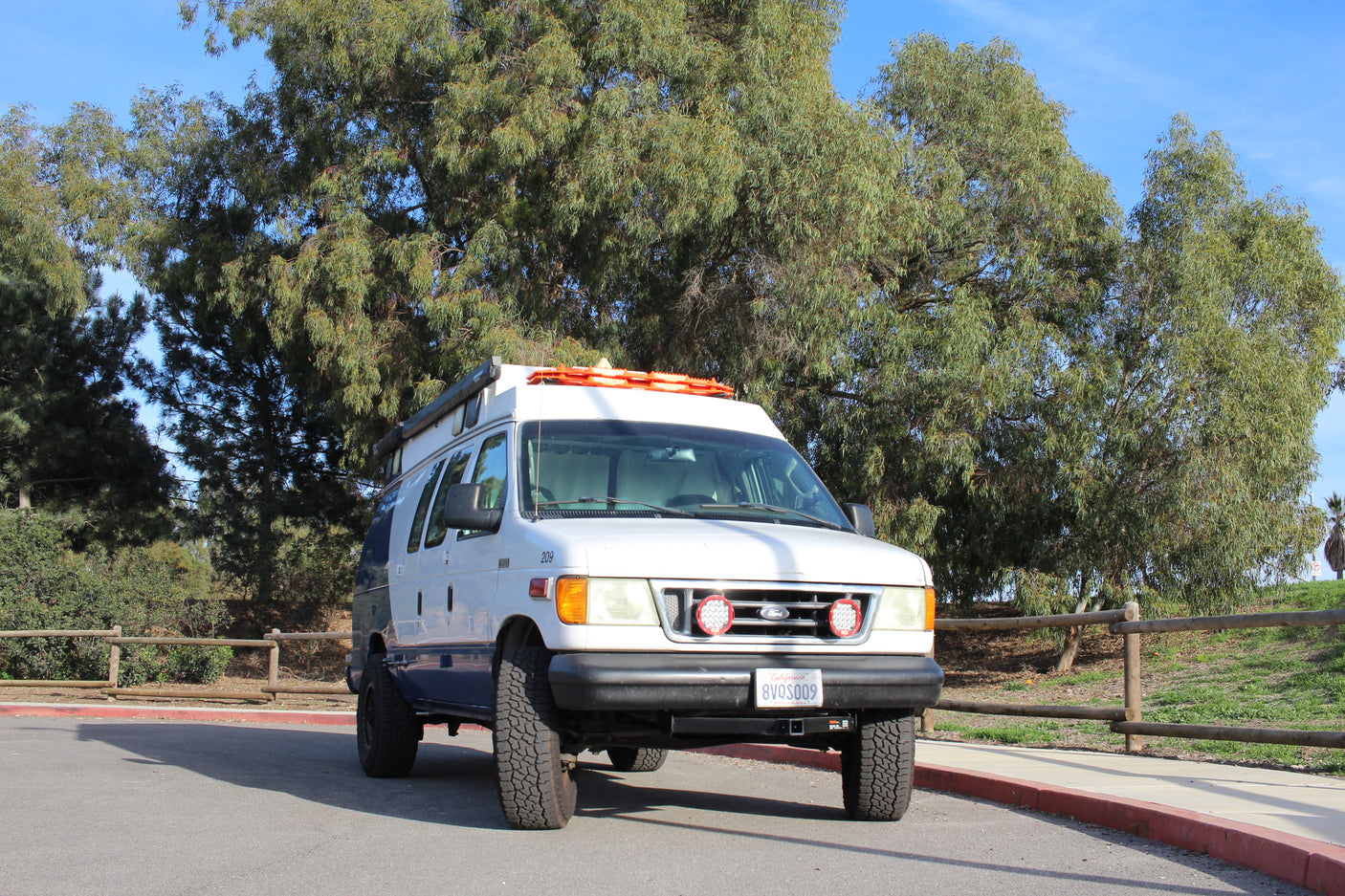 White Ford E-Series van RV rental, equipped for adventure, parked outdoors. Perfect camper van for travel.