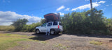 White SUV with an open rooftop tent & ladder. A great compact RV rental option for nature adventures.