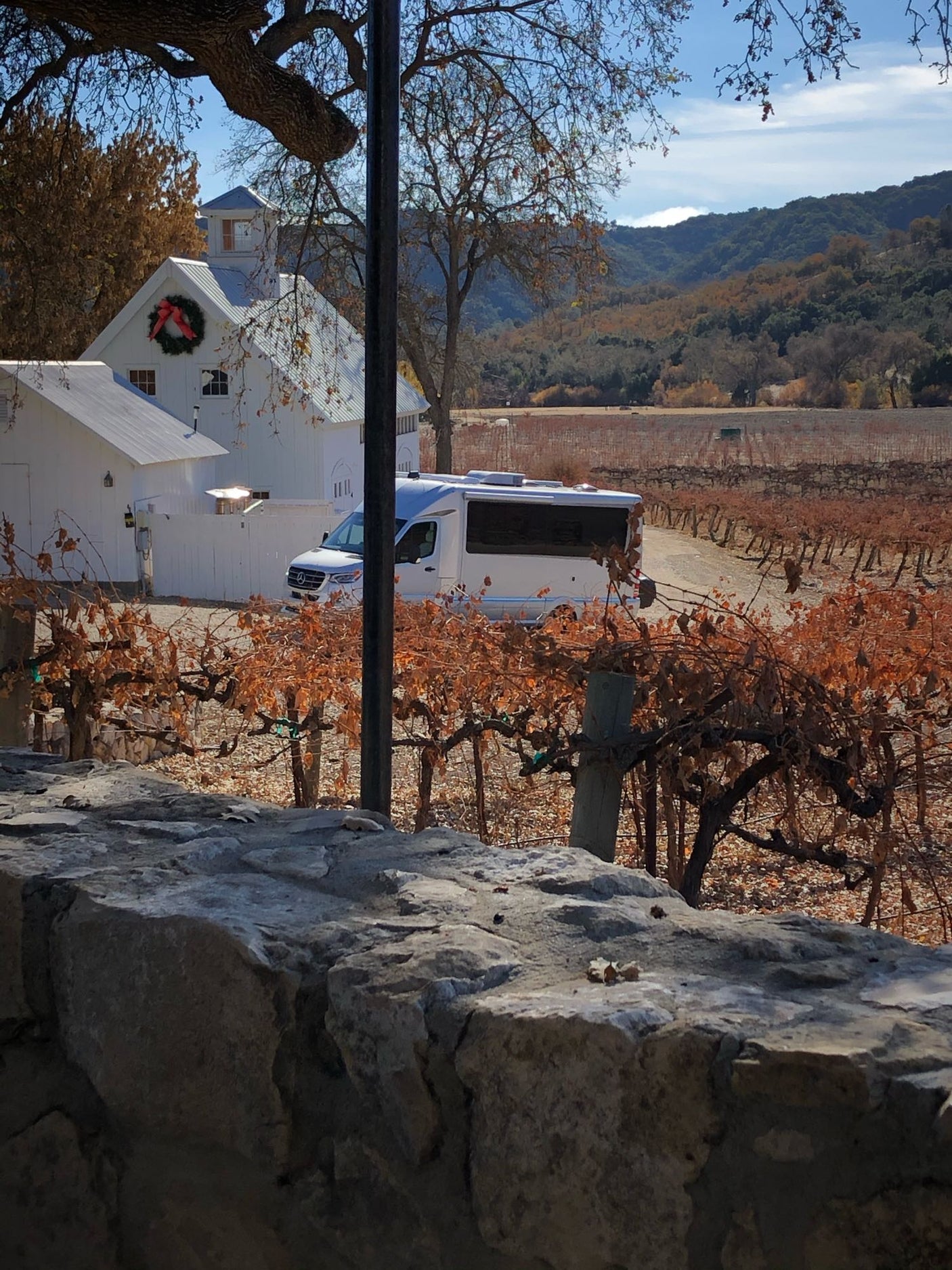 RV rental at an autumn vineyard, featuring white buildings, dormant vines, and distant mountains. Perfect for wine country.