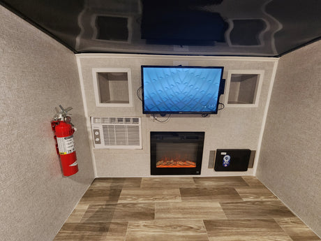 This rv rental's media nook offers a wall-mounted TV, electric fireplace, AC, and secure safe, with a fire extinguisher for safety.