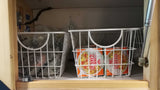 RV rental: Cabinet pantry with wire baskets organizes compostable bags & Nissin Cup Noodles, maximizing compact space.