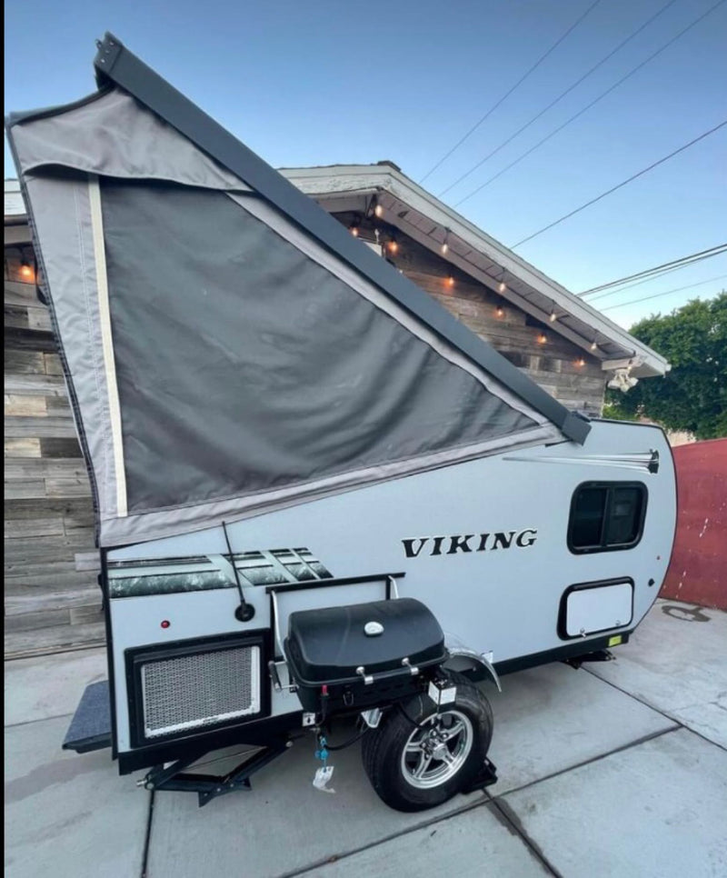  parked against a wooden wall with festive lights.|This A-frame Viking RV rental — photo 2