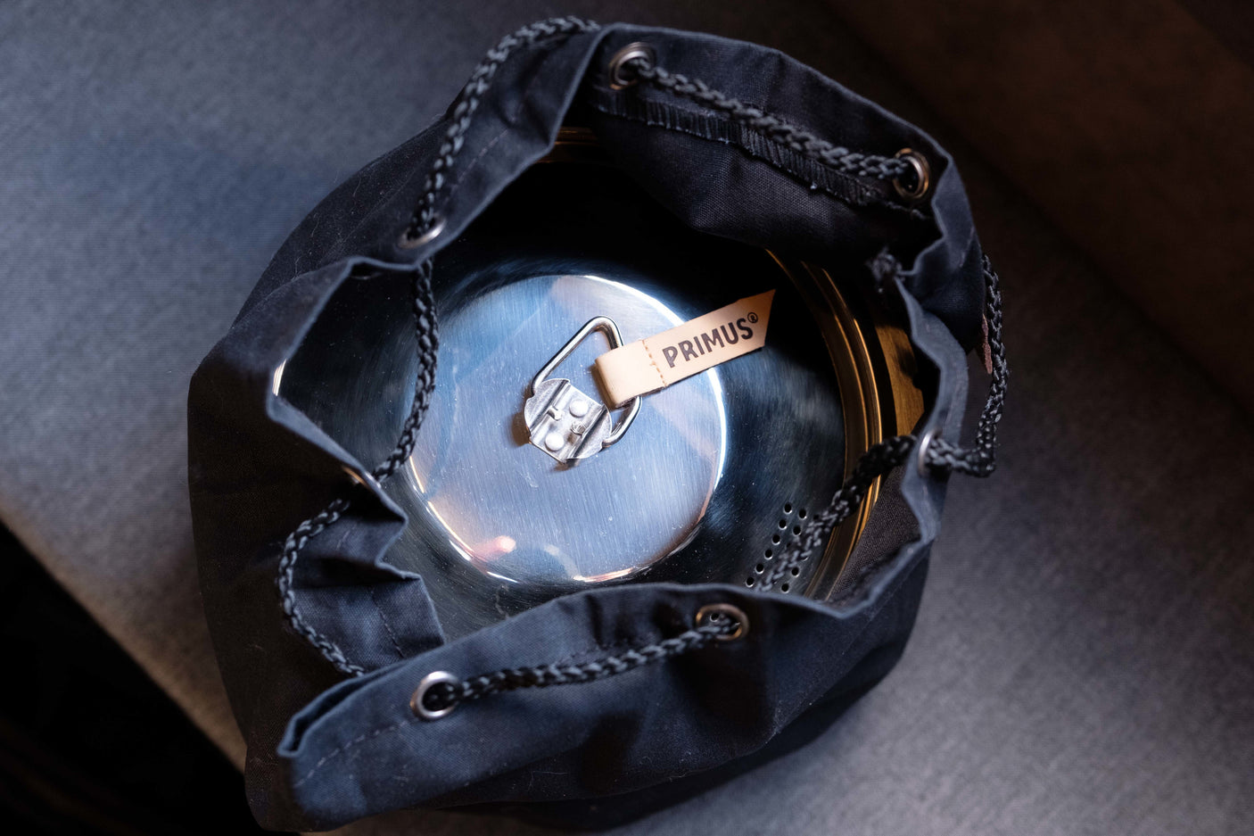 A Primus camping pot in a black drawstring bag, essential cookware for an RV rental trip.