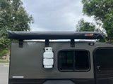 Side of an rv rental: gray camper with a 23ZERO awning, propane tank, and window. Perfect for outdoor adventure!