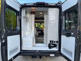 Explore this rv rental's rear: compact wet bath with shower, toilet, & utility storage. Perfect for mobile adventures!