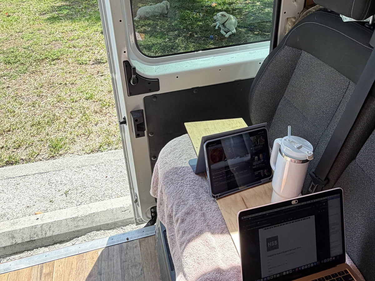  and picnic table.|White camper van RV rental in a wooded campsite — photo 3
