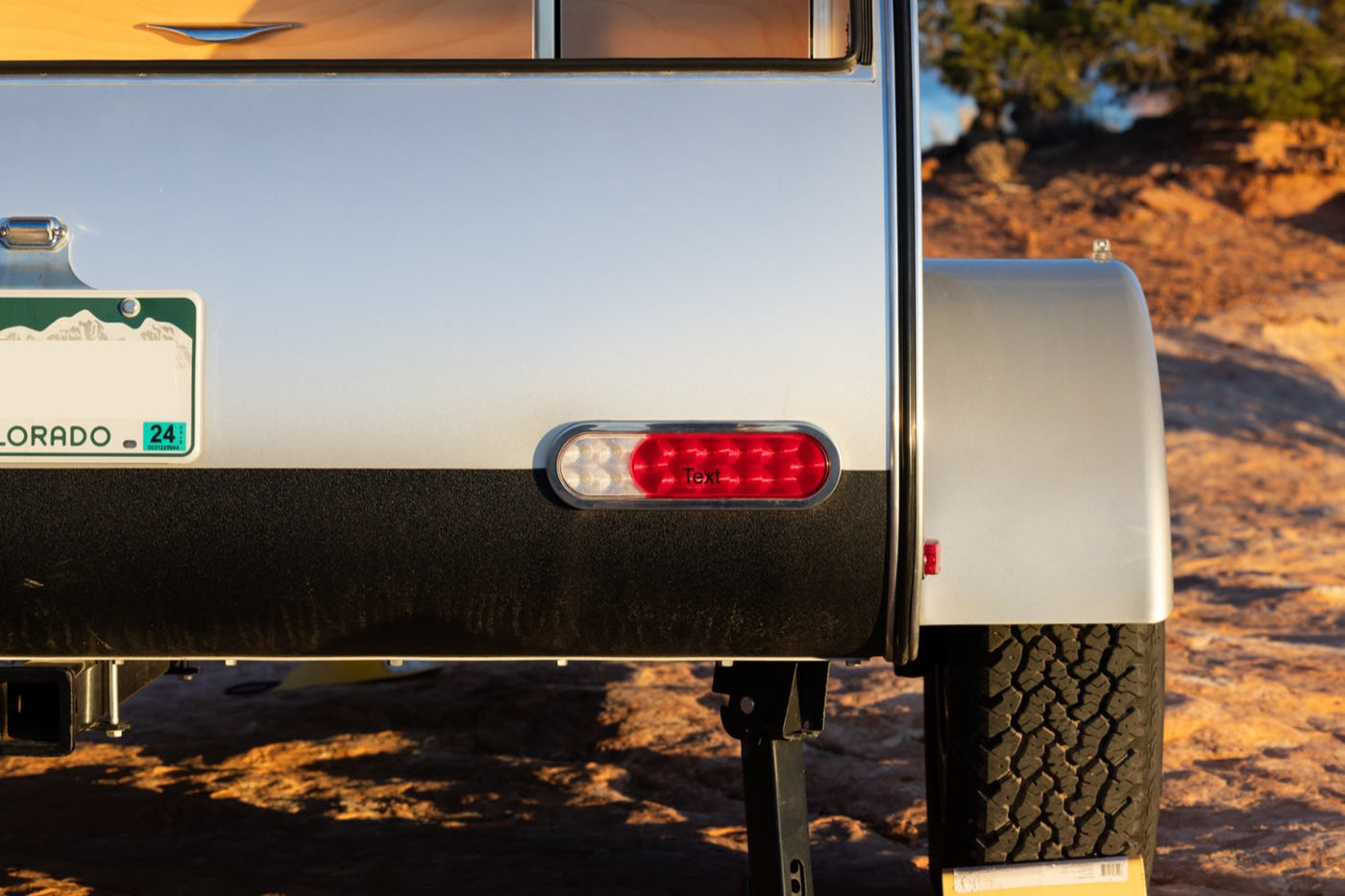  pulling food from a Dometic fridge amidst scenic rocks.|Explore outdoors! Rear of an RV rental camper with Colorado plate — photo 3