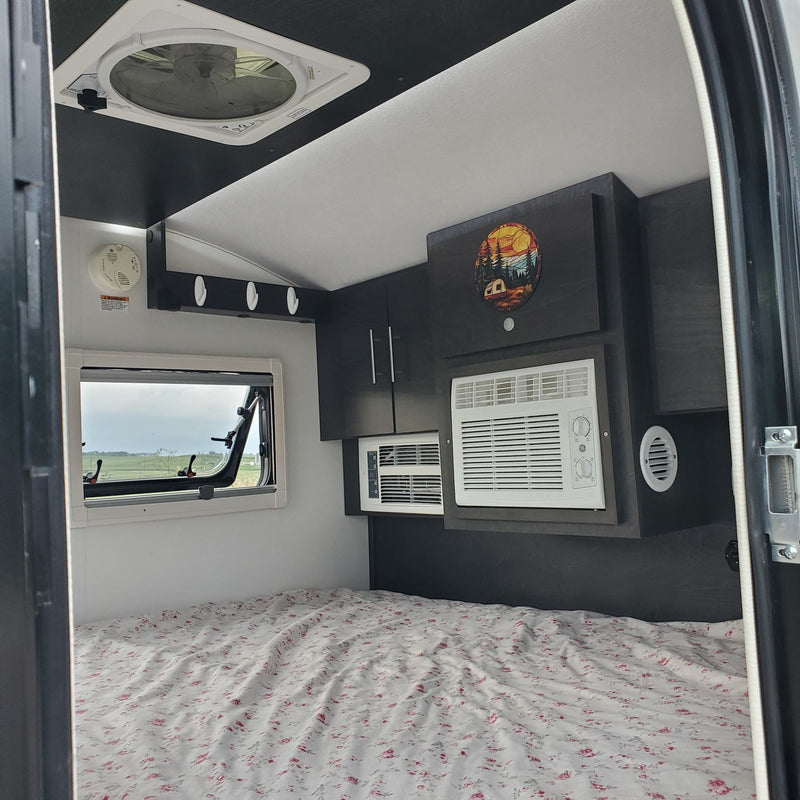 RV rental: Comfortable interior with bed, window, dual AC units, and overhead storage. — photo 15