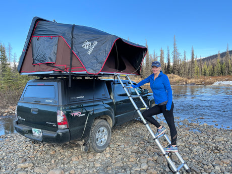 Exploring nature with an iKamper rooftop tent on a Toyota Tacoma by a scenic river. A great RV rental alternative for outdoor travel.