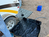 Camping with an **rv rental**: a teardrop trailer, outdoor shower spraying into a black basin, power unit, and water containers.