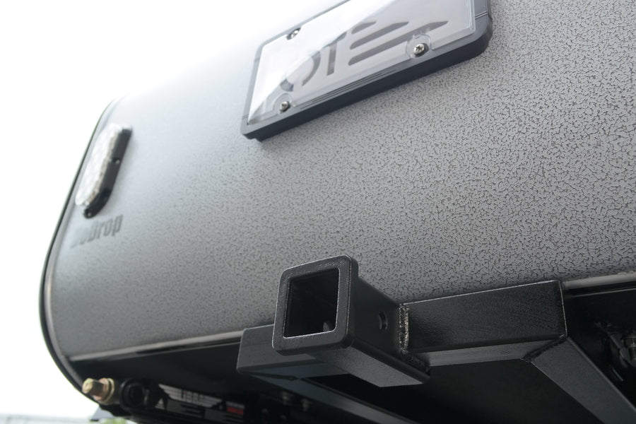Textured grey Teardrop travel trailer rear, with license plate frame and hitch receiver for RV rental adventures.