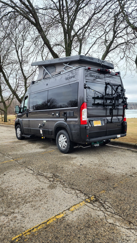 This dark gray Scope pop-top camper van with bike rack makes a great rv rental for scenic trips by the water.