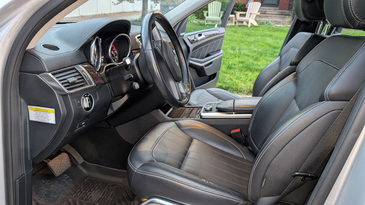 Detailed car interior view: dashboard, steering wheel, and black leather seats, ready for your road trip or rv rental adventure.