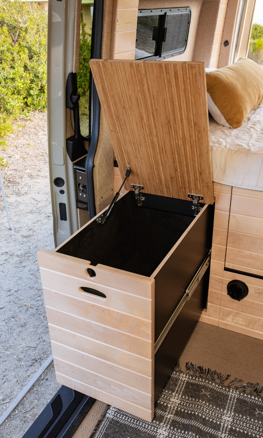 RV rental storage: A pull-out drawer and its open lid, offering clever storage in a modern camper van interior.