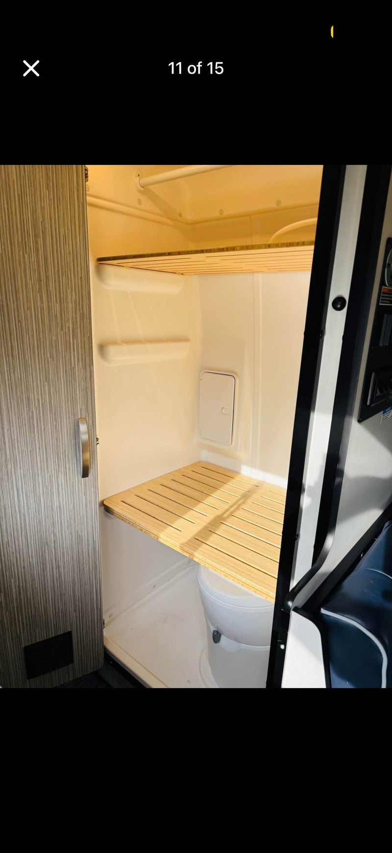 RV rental's compact bathroom: shower, toilet with slatted wooden cover, and overhead shelf for versatile space. — photo 8