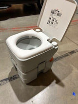 A gray portable chemical toilet with an open lid & white seat. Essential for RV rental camping sanitation.