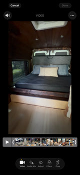 Previewing an RV rental video: Cozy camper van bed setup with wooden interior & nature view. Video editing tools visible.
