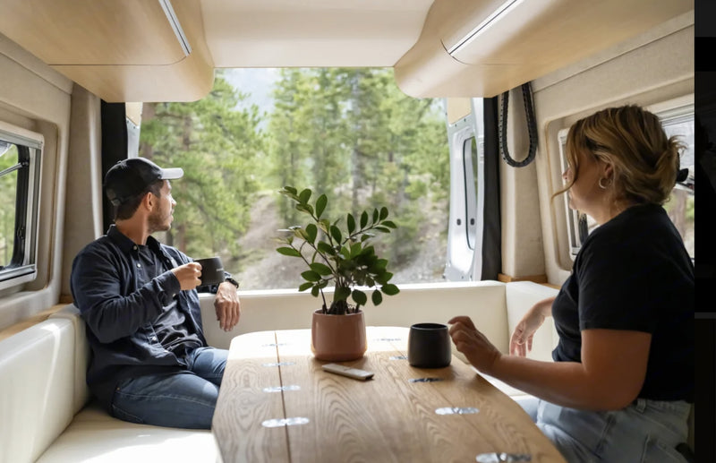  parked at a desert campsite with a beautiful sunset sky.|Modern RV rental interior with a cozy kitchen — photo 2