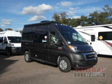 Dark gray ProMaster camper van, perfect for rv rental, is parked between a white van and a large RV.