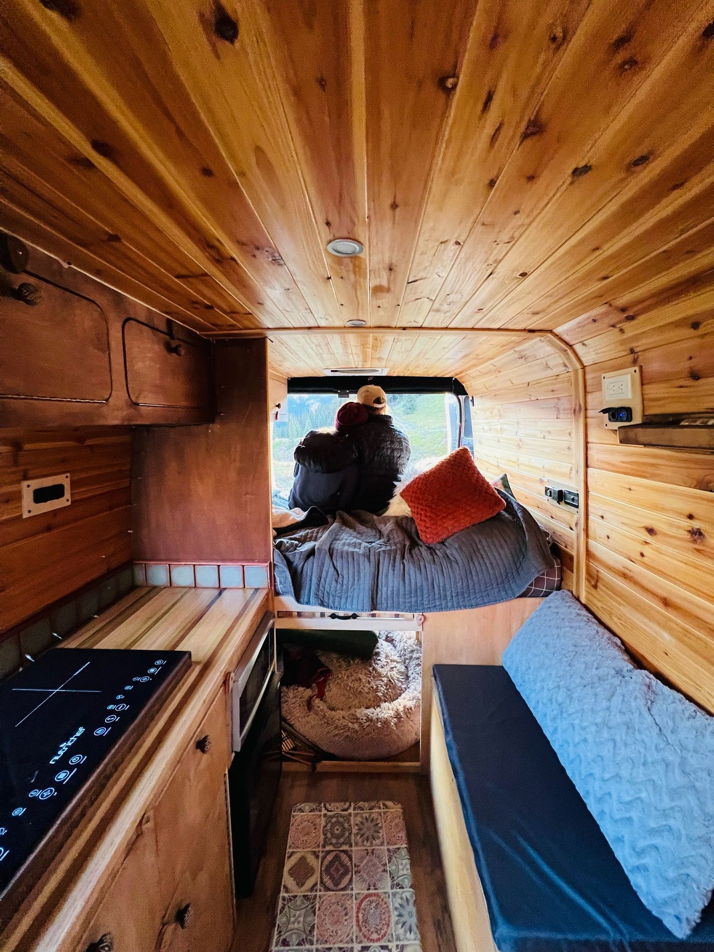  and microwave. Ideal for your next adventure.|Warm wood-paneled RV rental interior with a comfy bed in the foreground — photo 3