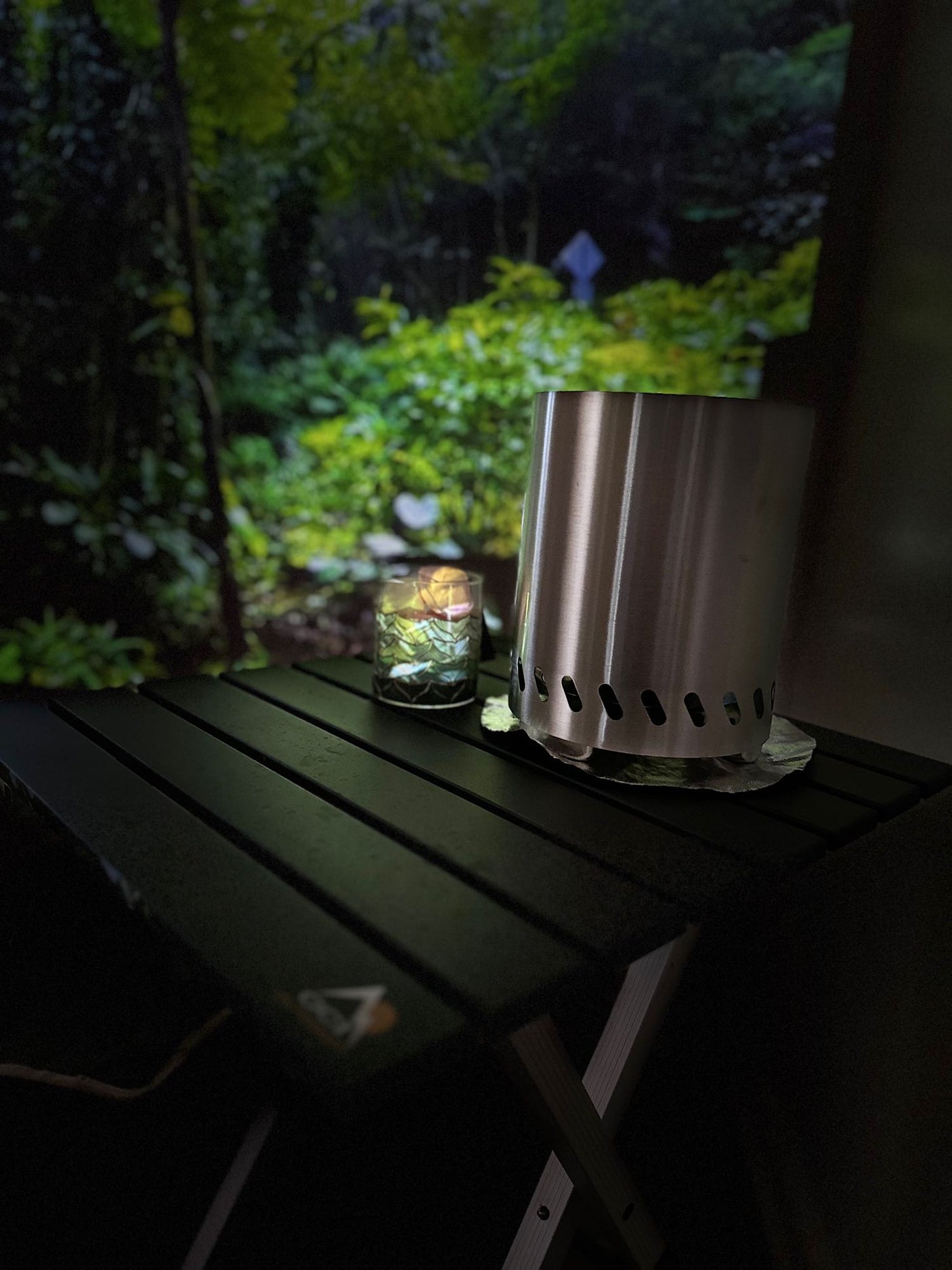 Cozy RV rental setup: a portable fire pit, glowing lamp on a table, creating an indoor forest escape.