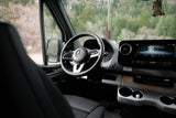 Interior of a modern Mercedes-Benz RV rental, showing the driver's seat, steering wheel, and dashboard display.