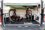 RV rental: efficient storage for a mountain bike (wheel off), water system, and gear in a converted camper van.